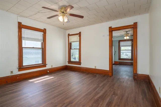 a view of an empty room with window and wooden floor
