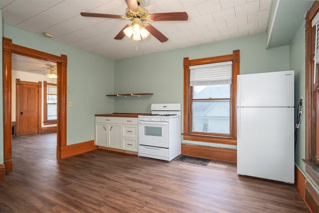 a kitchen with stainless steel appliances white cabinets and wooden floor