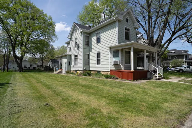 a view of a house with a yard and a tree