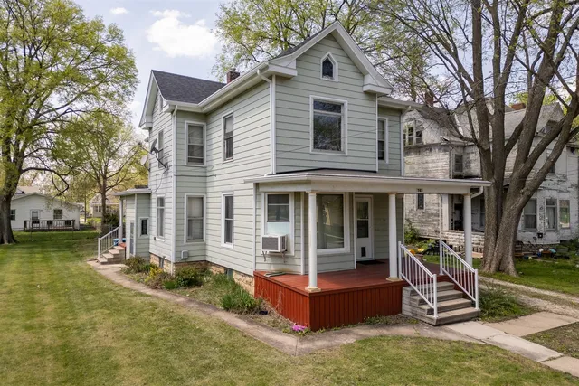 a view of a house with a yard and large tree