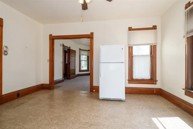 an empty room with closet and windows