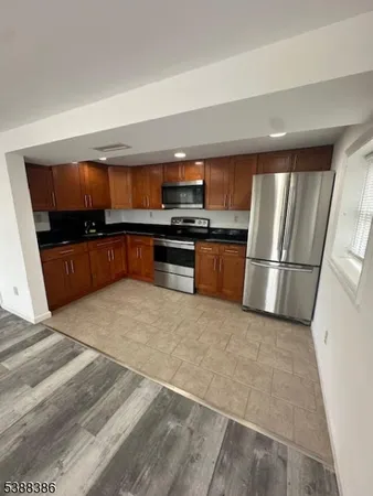 a kitchen with granite countertop a refrigerator and a stove top oven