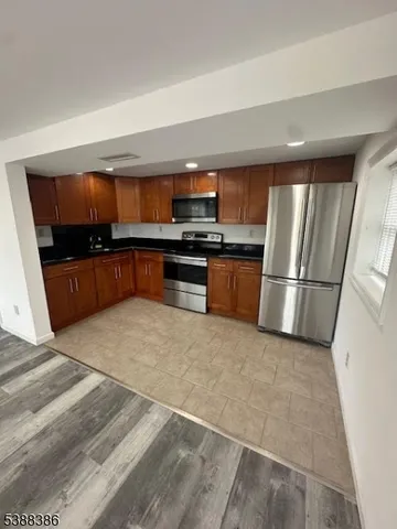 a kitchen with granite countertop a refrigerator and a stove top oven