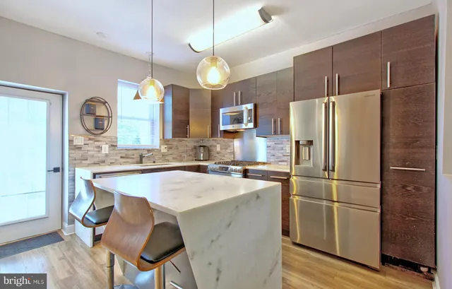 a kitchen with cabinets a refrigerator a sink and a stove top oven