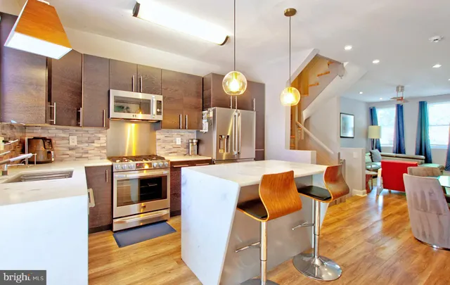 a kitchen with stainless steel appliances granite countertop a sink a stove and a wooden floors