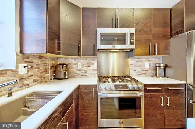 a kitchen with stainless steel appliances granite countertop a sink stove and refrigerator