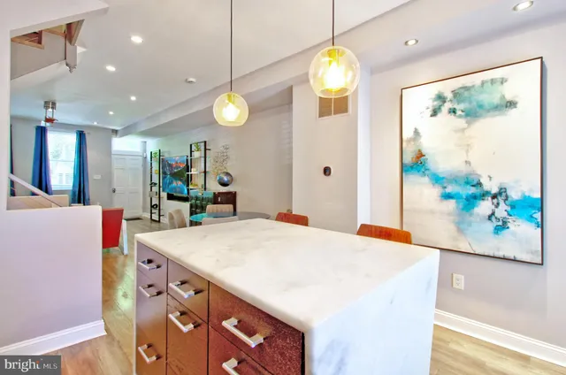 a kitchen that has a lot of cabinets a sink and a wooden floor
