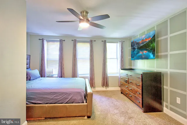 a bedroom with a bed and a painting on the wall