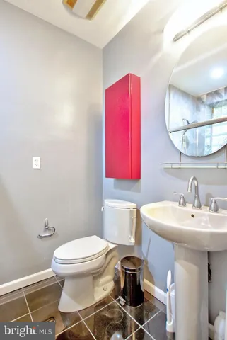 a bathroom with a sink a toilet and a mirror