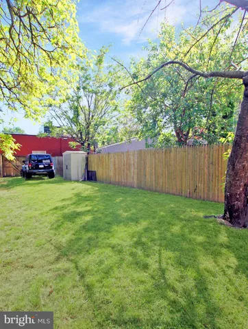 a view of a patio with table and chairs potted plants and large tree