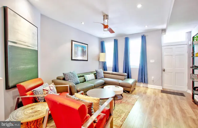 a living room with furniture a rug and a painting on the wall