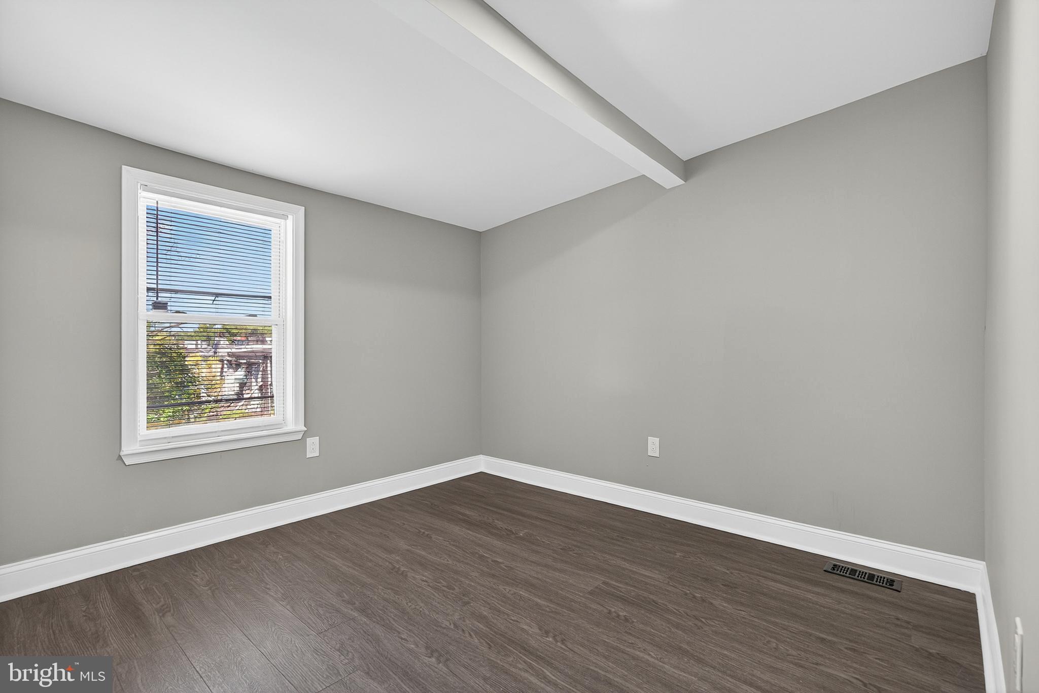 320 South Pulaski Street Baltimore, MD 21223 - Photo 21 of 46 a view of an empty room with wooden floor and a window