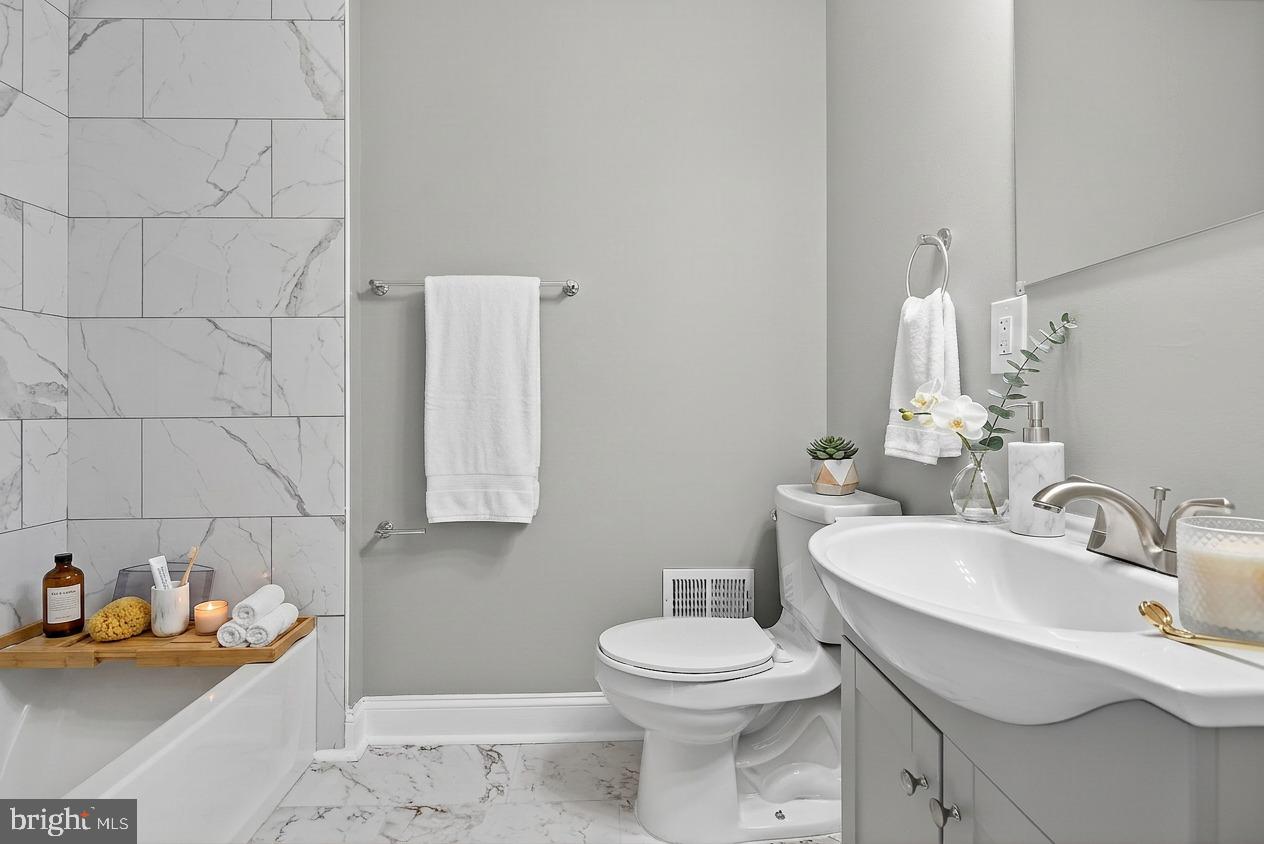 320 South Pulaski Street Baltimore, MD 21223 - Photo 22 of 46 a bathroom with a toilet sink and mirror