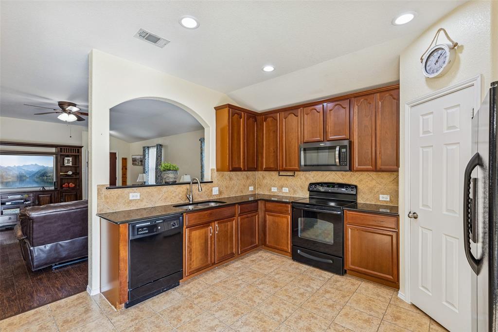 506 Austin Lane Lavon, TX 75166 - Photo 11 of 24 a kitchen with stainless steel appliances granite countertop a stove top oven a sink a refrigerator and a microwave