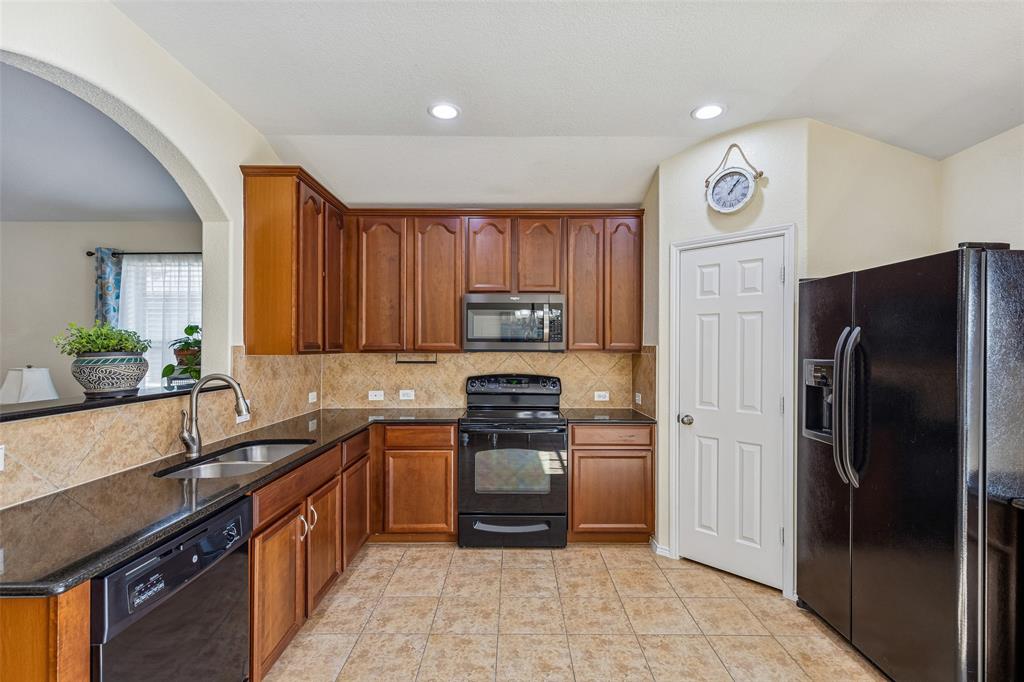 506 Austin Lane Lavon, TX 75166 - Photo 12 of 24 a kitchen with a sink a refrigerator and cabinets