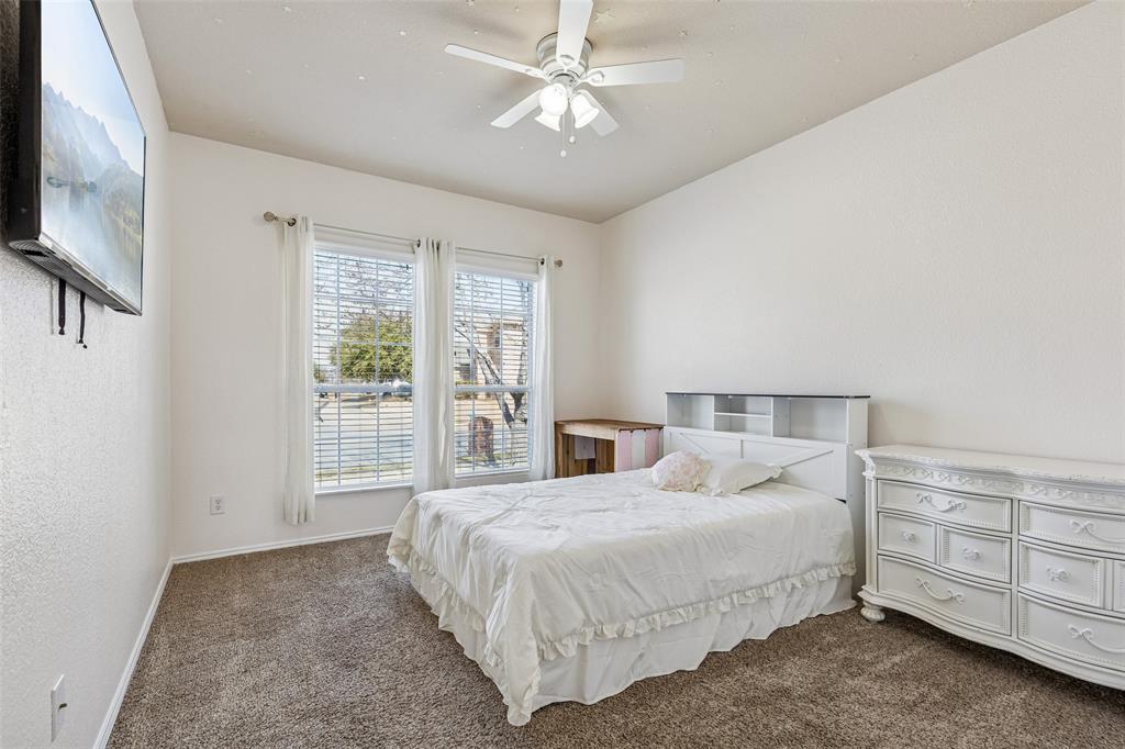 506 Austin Lane Lavon, TX 75166 - Photo 8 of 24 a bedroom with a bed a dresser and a chandelier