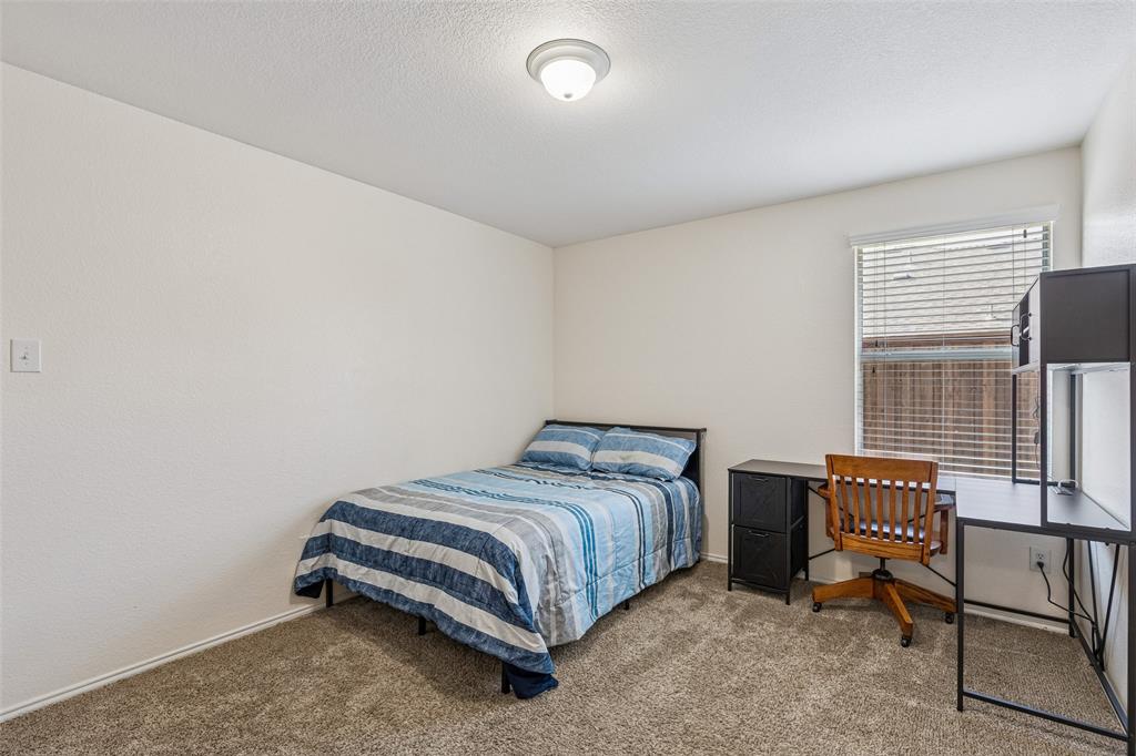 506 Austin Lane Lavon, TX 75166 - Photo 10 of 24 a bedroom with a bed and a chair