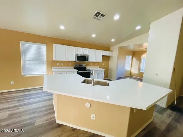 a kitchen with kitchen island a sink stainless steel appliances and window