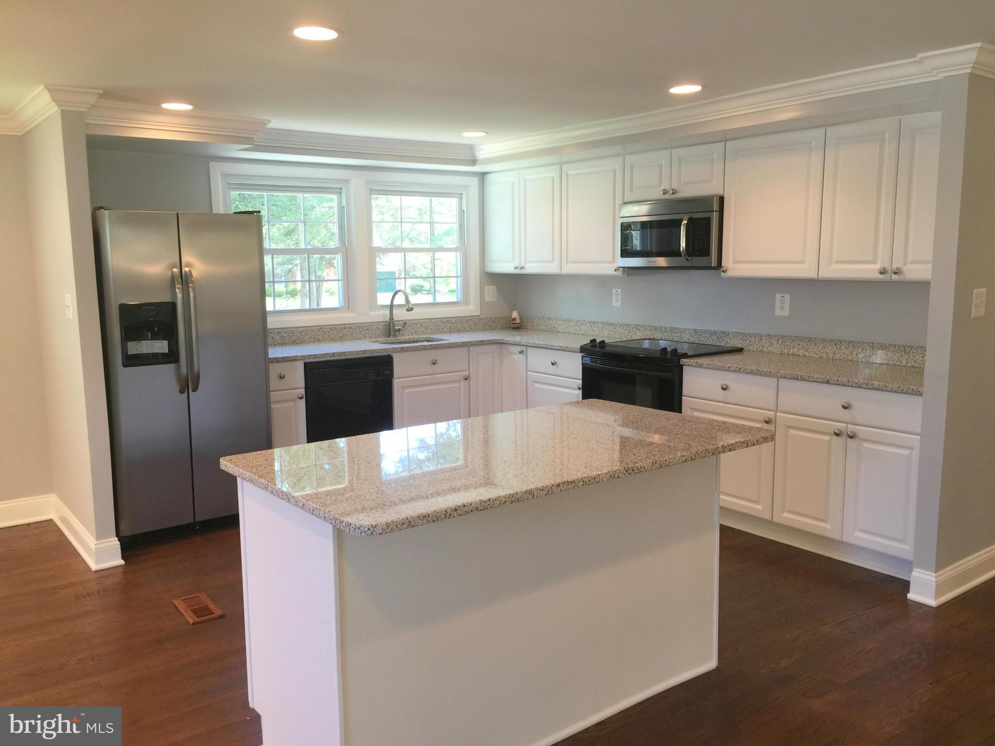 5146 Downwest Ride Columbia, MD 21044 - Photo 1 of 26 a kitchen with kitchen island white cabinets appliances and sink