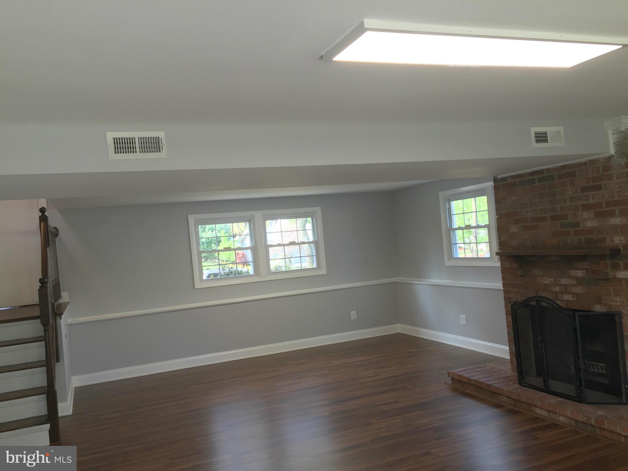 5146 Downwest Ride Columbia, MD 21044 - Photo 10 of 26 an empty room with wooden floor fireplace and windows