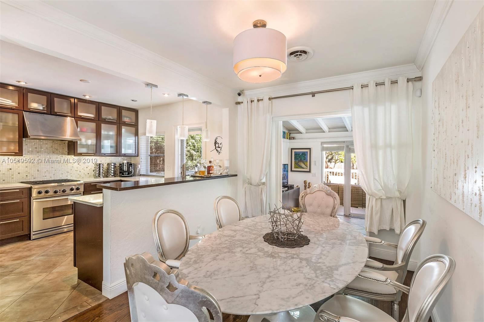 131 Southwest 23rd Road Miami, FL 33129 - Photo 6 of 20 a kitchen with granite countertop a table and chairs