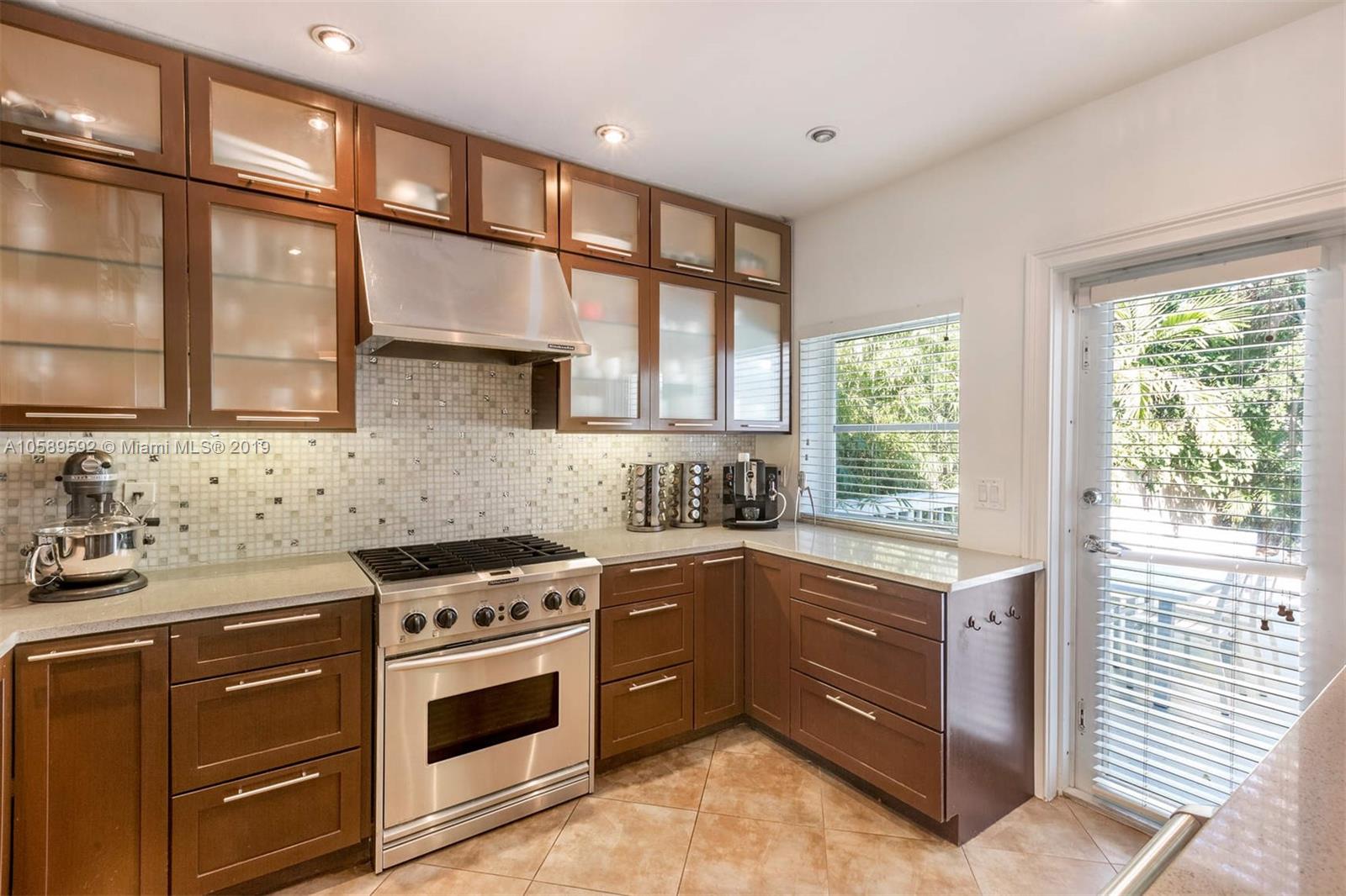 131 Southwest 23rd Road Miami, FL 33129 - Photo 8 of 20 a kitchen with stainless steel appliances a stove sink and cabinets