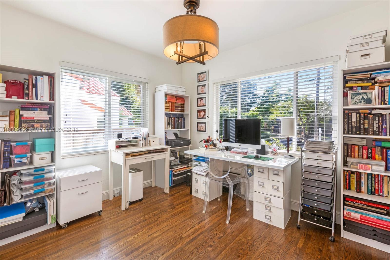 131 Southwest 23rd Road Miami, FL 33129 - Photo 9 of 20 a view of a workspace with furniture and a bookshelf