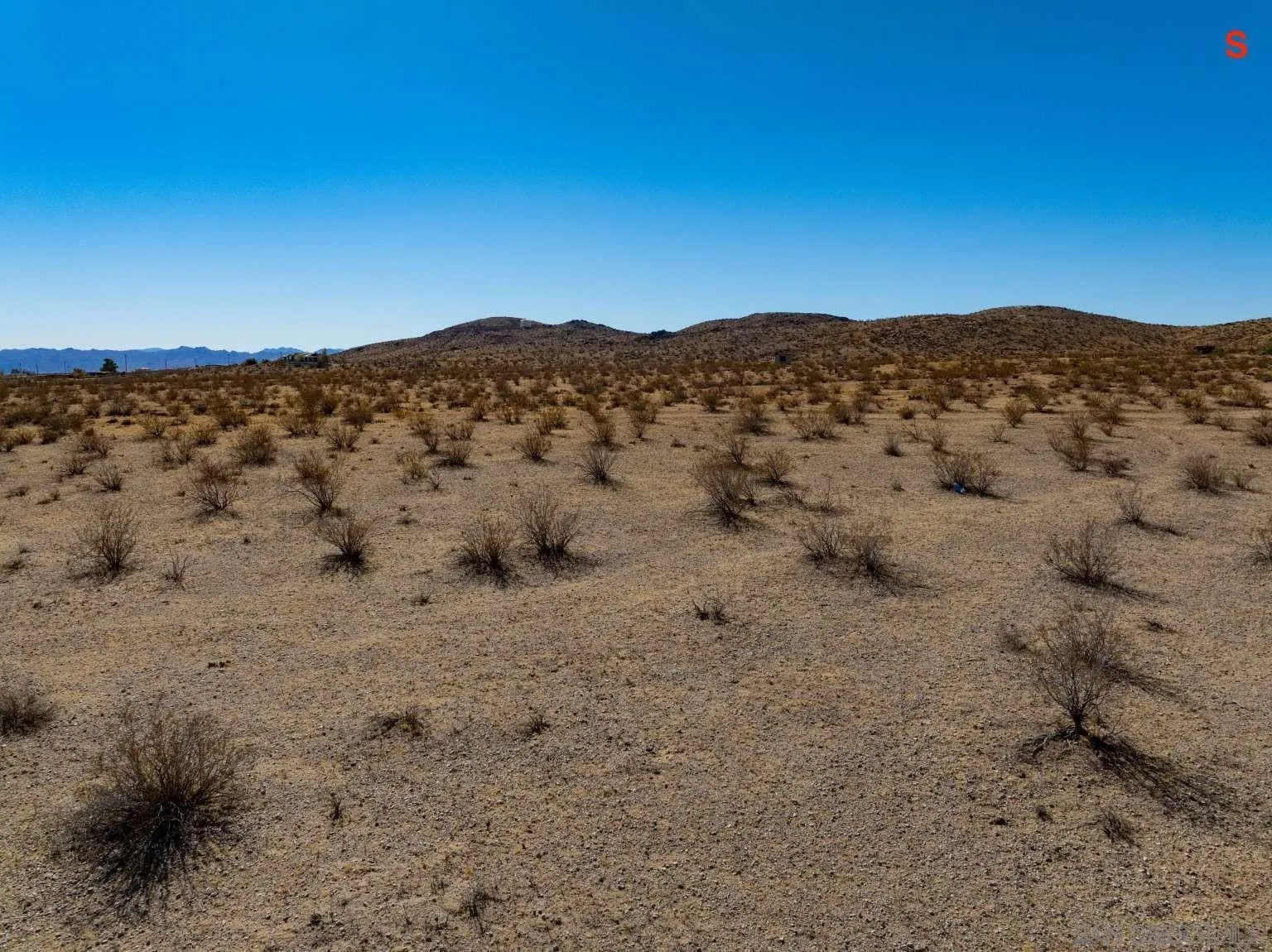 0 Sharp Terrace Drive, Unit 24 Joshua Tree, CA 92252 - Photo 19 of 40 a view of a dry field with mountains in the background