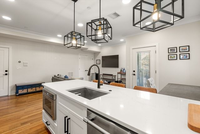 a kitchen with a sink a counter space and wooden floor