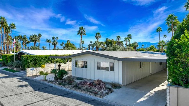 a view of a white house with large windows and plants