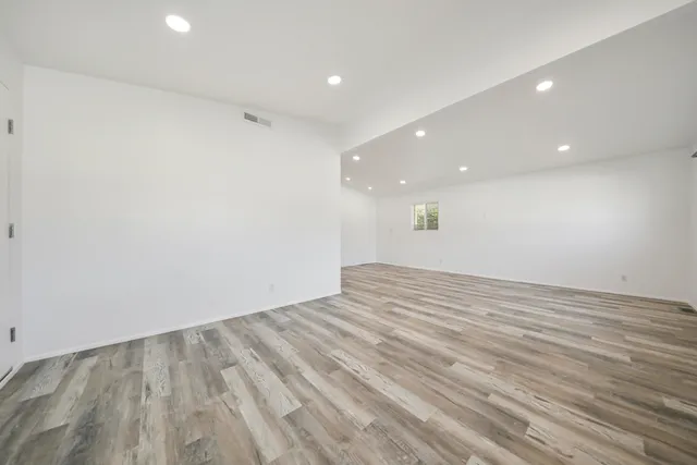 a view of empty room with wooden floor