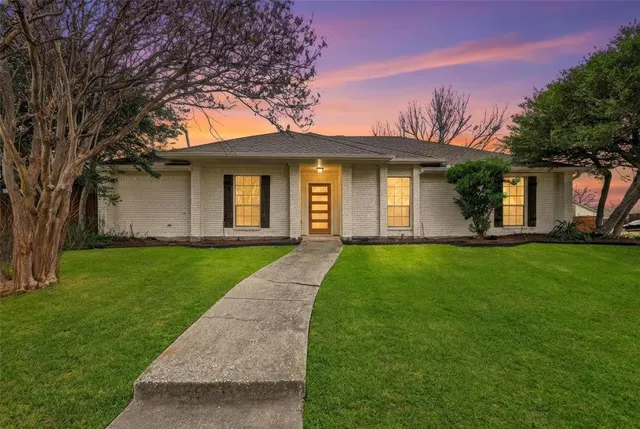 a front view of a house with a yard and trees