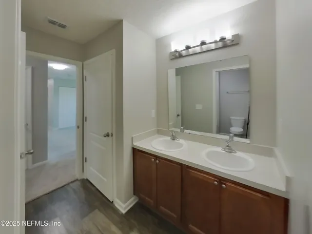 a bathroom with a double vanity sink and mirror