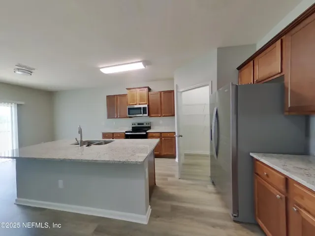 a kitchen with stainless steel appliances a refrigerator sink and stove