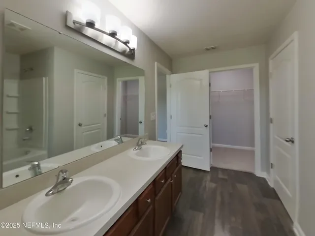 a bathroom with a sink double vanity granite tub and shower