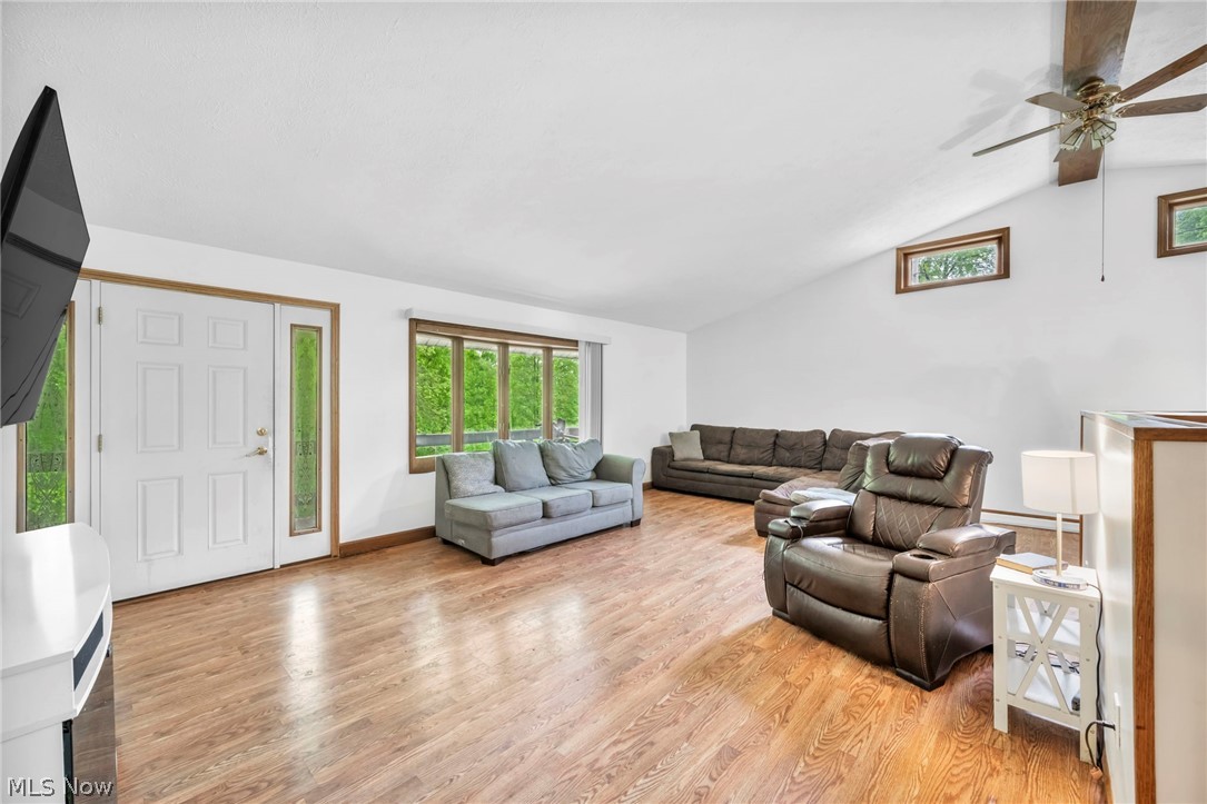 4560 Arrow Road Northwest Carrollton, OH 44615 - Photo 5 of 41 Living room featuring light wood-type flooring, vaulted ceiling, and ceiling fan