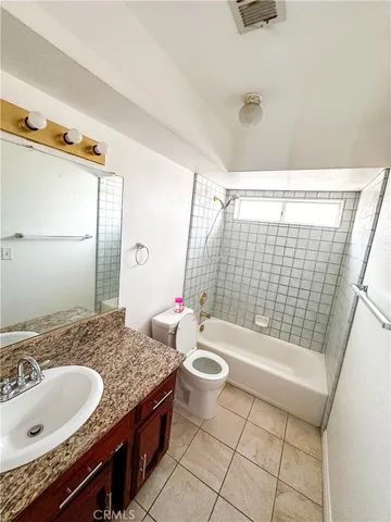 a bathroom with a granite countertop sink a toilet a mirror and shower