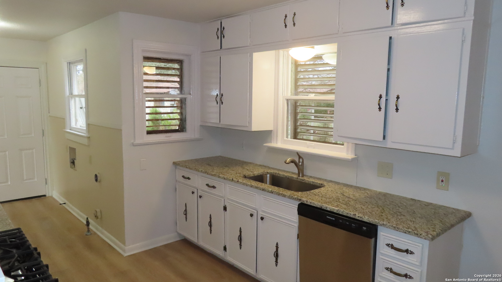 3423 South WW White Road San Antonio, TX 78222 - Photo 7 of 20 a kitchen with granite countertop a sink window and cabinets