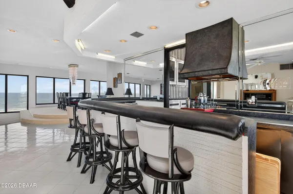 a kitchen with stainless steel appliances kitchen island granite countertop a stove a sink and a dining table