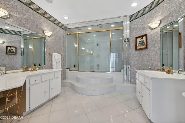 a large bathroom with a sink a large mirror and a shower