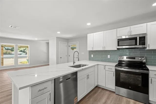 a kitchen with a sink stove and microwave