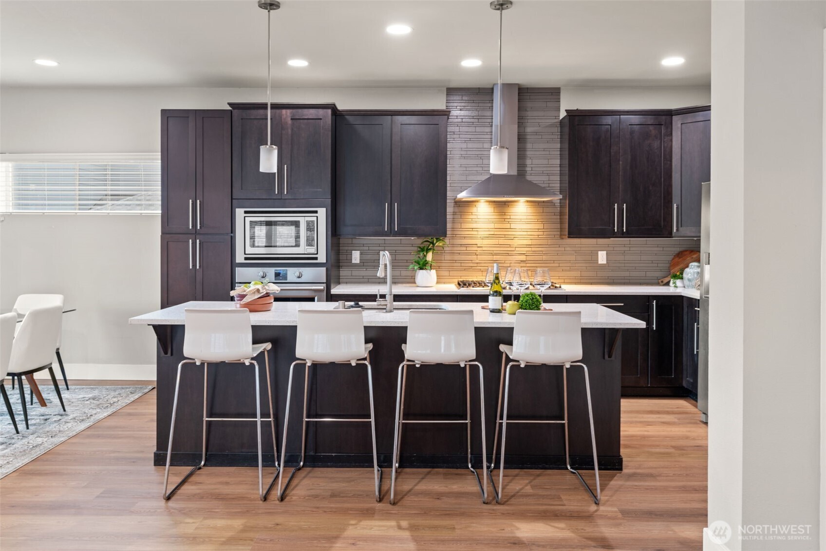 4408 214th Place Southeast Bothell, WA 98021 - Photo 14 of 33 a kitchen with stainless steel appliances kitchen island granite countertop a table chairs sink and cabinets