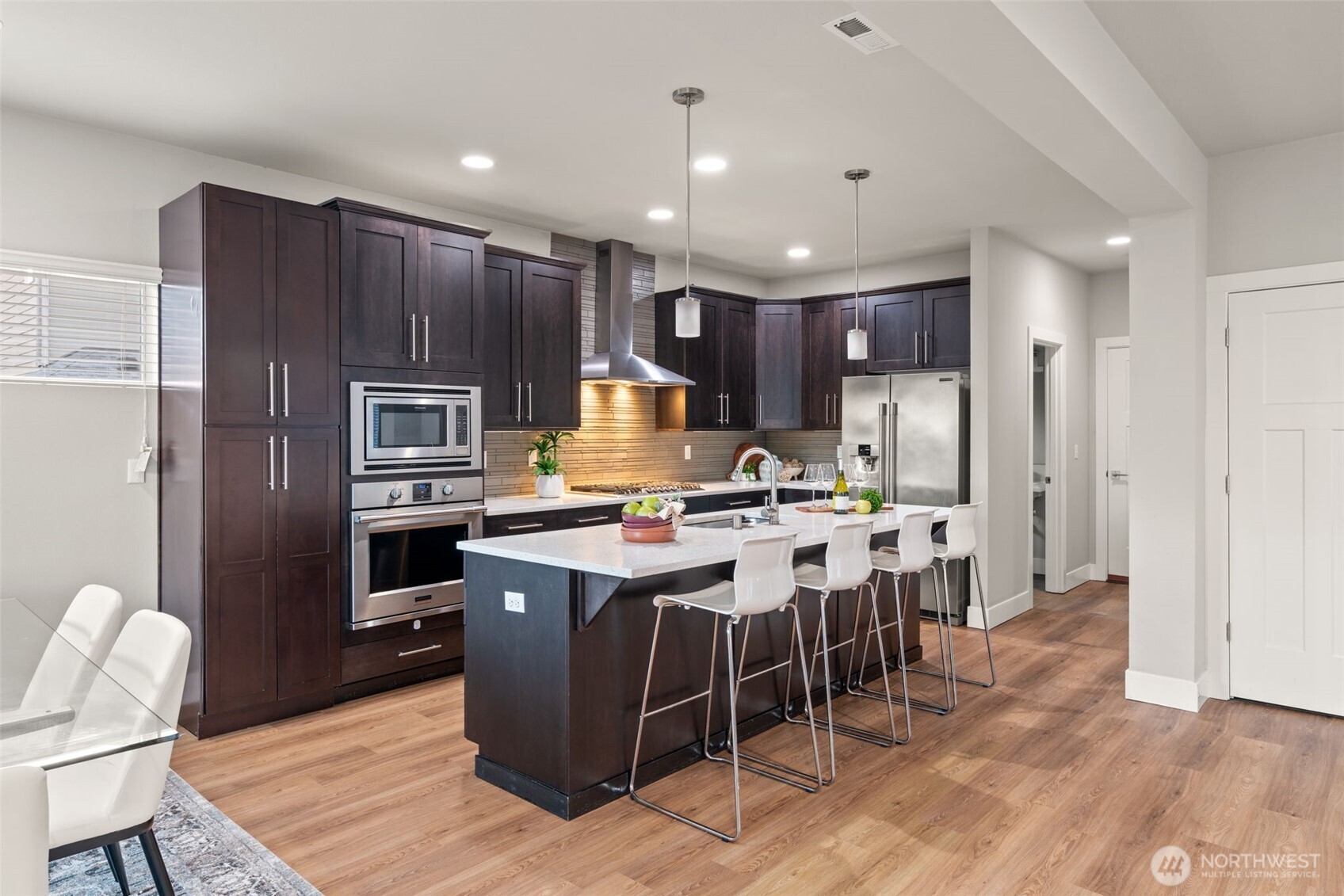 4408 214th Place Southeast Bothell, WA 98021 - Photo 15 of 33 a kitchen with stainless steel appliances kitchen island granite countertop a table chairs sink refrigerator and microwave
