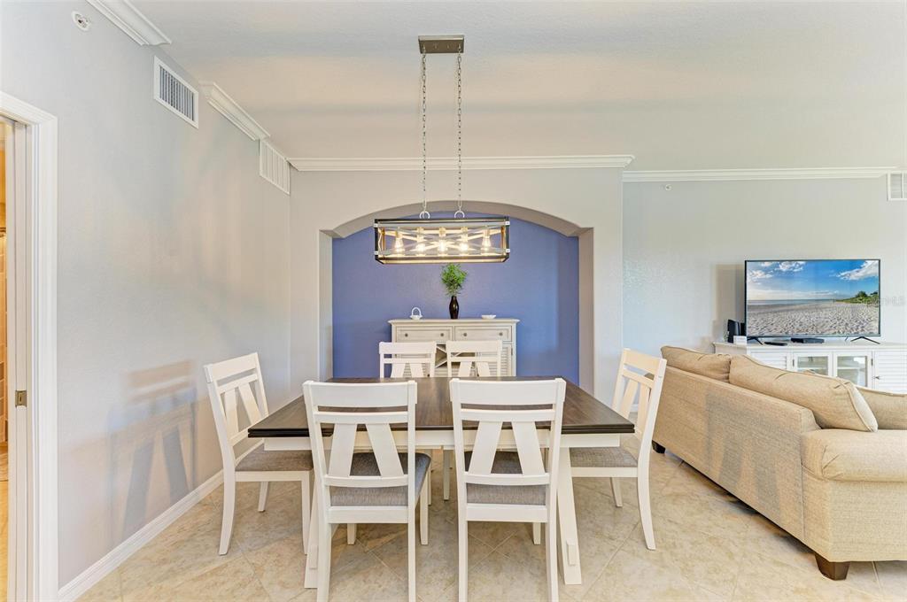 424 Winding Brook Lane, Unit 104 Bradenton, FL 34212 - Photo 16 of 72 a view of a dining room with furniture a chandelier and wooden floor