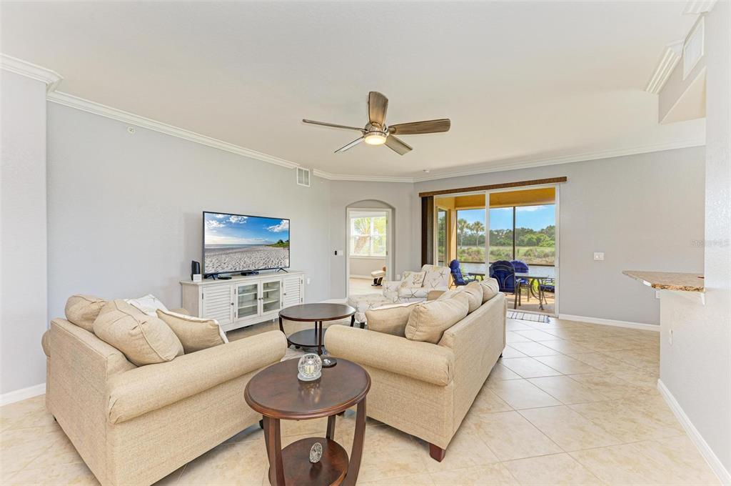 424 Winding Brook Lane, Unit 104 Bradenton, FL 34212 - Photo 31 of 72 a living room with furniture a large window and a chandelier