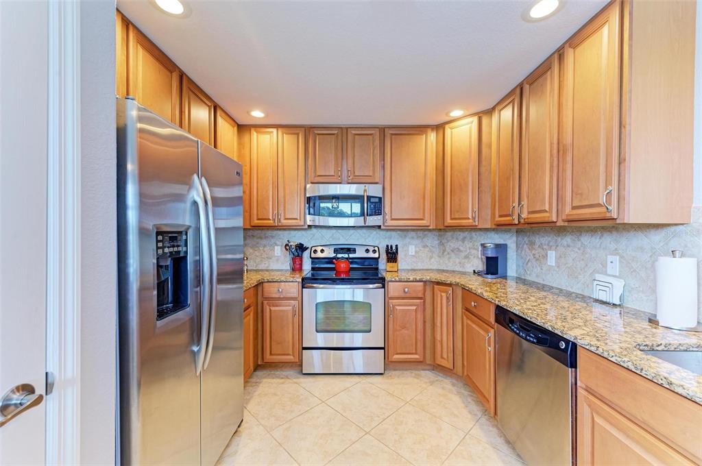 424 Winding Brook Lane, Unit 104 Bradenton, FL 34212 - Photo 9 of 72 a kitchen with stainless steel appliances granite countertop a refrigerator and a sink