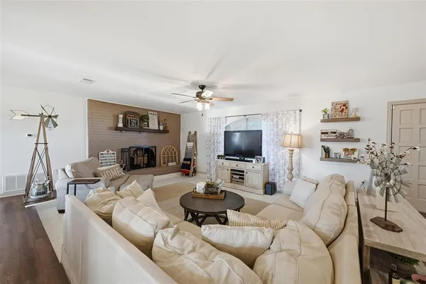 a living room with furniture a flat screen tv and a fireplace