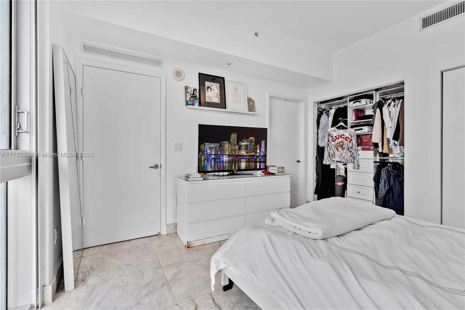 92 Southwest 3rd Street, Unit 5106 Miami, FL 33130 - Photo 20 of 36 a bedroom with a bed and a mirror