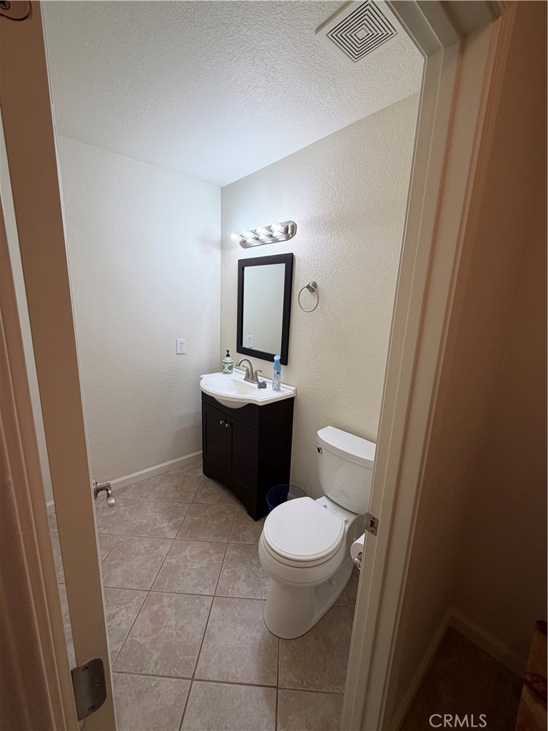 209 Kimberly Lane Ridgecrest, CA 93555 - Photo 36 of 62 a bathroom with a toilet a sink a rug and mirror