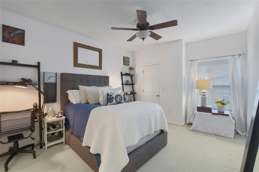 955 Juniper Street Northeast, Unit 4324 Atlanta, GA 30309 - Photo 11 of 26 a spacious bedroom with a bed and a chandelier